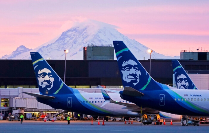 Aviones de Alaska Airlines aparcados en las puertas de embarque con el Monte Rainier de fondo al amanecer, en el Aeropuerto Internacional de Seattle-Tacoma en Seattle el 1 de marzo de 2021. (Ted S. Warren/Foto AP). 