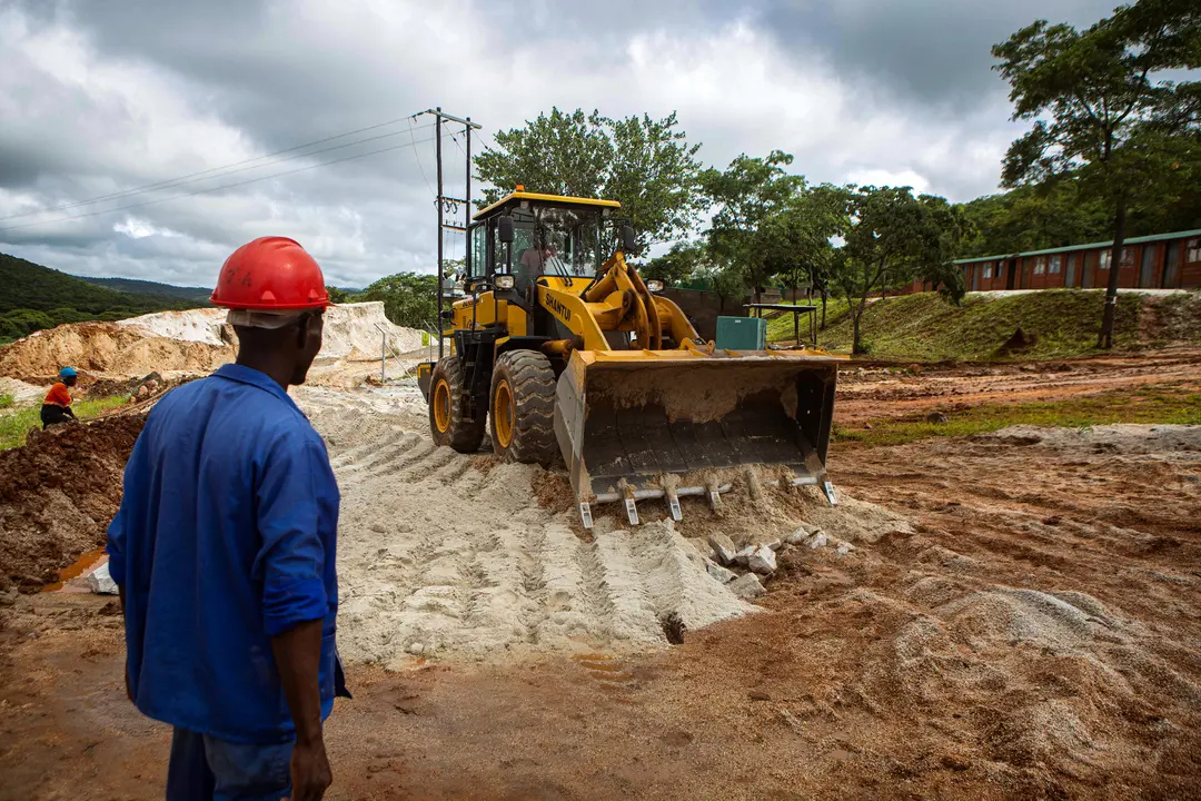 Un capataz observa mientras una excavadora trabaja en la resbaladiza carretera de la mina de litio de Arcadia en Goromonzi, Zimbabue, el 11 de enero de 2022. (Tafadzwa Ufumeli/Getty Images)