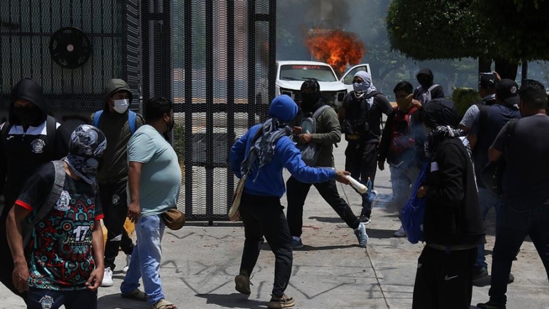 Jóvenes encapuchados incendian un carro este viernes 13 de septiembre de 2024, en Ayotzinapa (México). EFE/José Luis de la Cruz