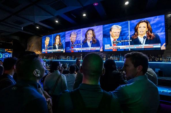 Un grupo de personas observa el debate presidencial entre la candidata presidencial demócrata, la vicepresidenta Kamala Harris, y el candidato presidencial republicano, el expresidente Donald Trump, en un evento celebrado en el bar Slate de Nueva York el 10 de septiembre de 2024. (Samira Bouaou/The Epoch Times)