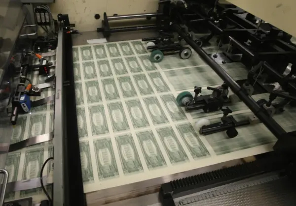 Hojas de billetes de 1 dólar pasan por la imprenta en la Oficina de Grabado e Impresión en Washington el 24 de marzo de 2015. (Mark Wilson/Getty Images)