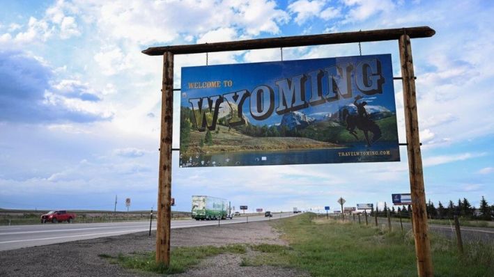 Vehículos pasan junto a un anuncio de bienvenida a lo largo de la I-25, al sur de Cheyenne, Wyoming, el 12 de agosto de 2022. (Patrick T. Fallon/AFP)