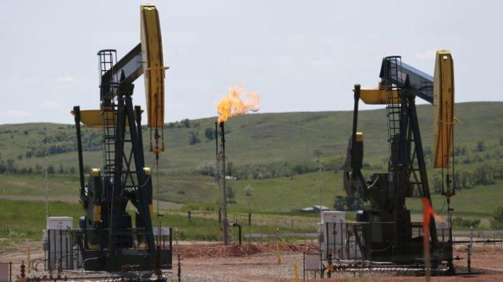 Bombeo de petróleo y quema de gas natural en un yacimiento petrolífero cerca de Watford City, Dakota del Norte, el 12 de junio de 2014. Charles Rex Arbogast/Foto AP