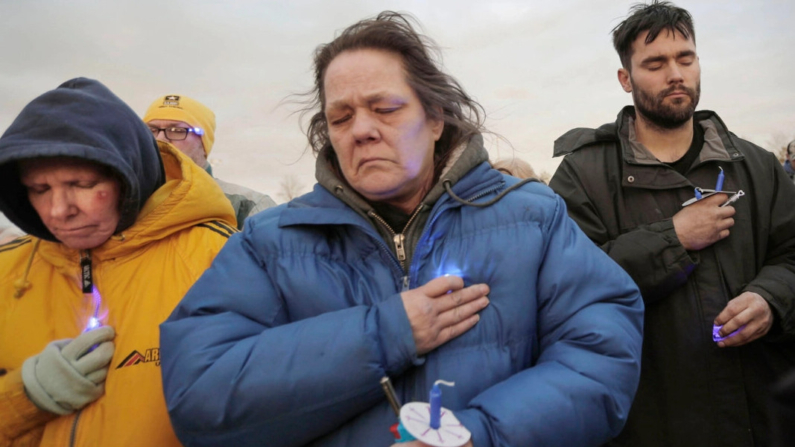 La gente hace una pausa durante una vigilia celebrada por Elijah Vue, de 3 años, en Walsh Field en Two Rivers, Wisconsin, el 16 de marzo de 2024. (Gary C. Klein/The Sheboygan Press vía AP)