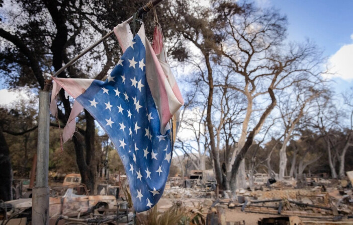 Una bandera estadounidense ondea entre los daños causados por el incendio Airport en El Cariso Village, California, el 16 de septiembre de 2024. (John Fredricks/The Epoch Times). 
