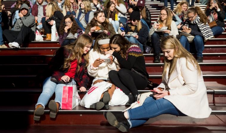 Un grupo de adolescentes mira una fotografía que tomaron con un teléfono inteligente en Times Square en la ciudad de Nueva York, el 1 de diciembre de 2017. (Drew Angerer/Getty Images)