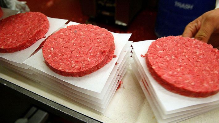  Una persona retira hamburguesas de carne picada de una cinta transportadora, el 29 de diciembre de 2003, en Yakima, Washington. (Justin Sullivan/Getty Images)