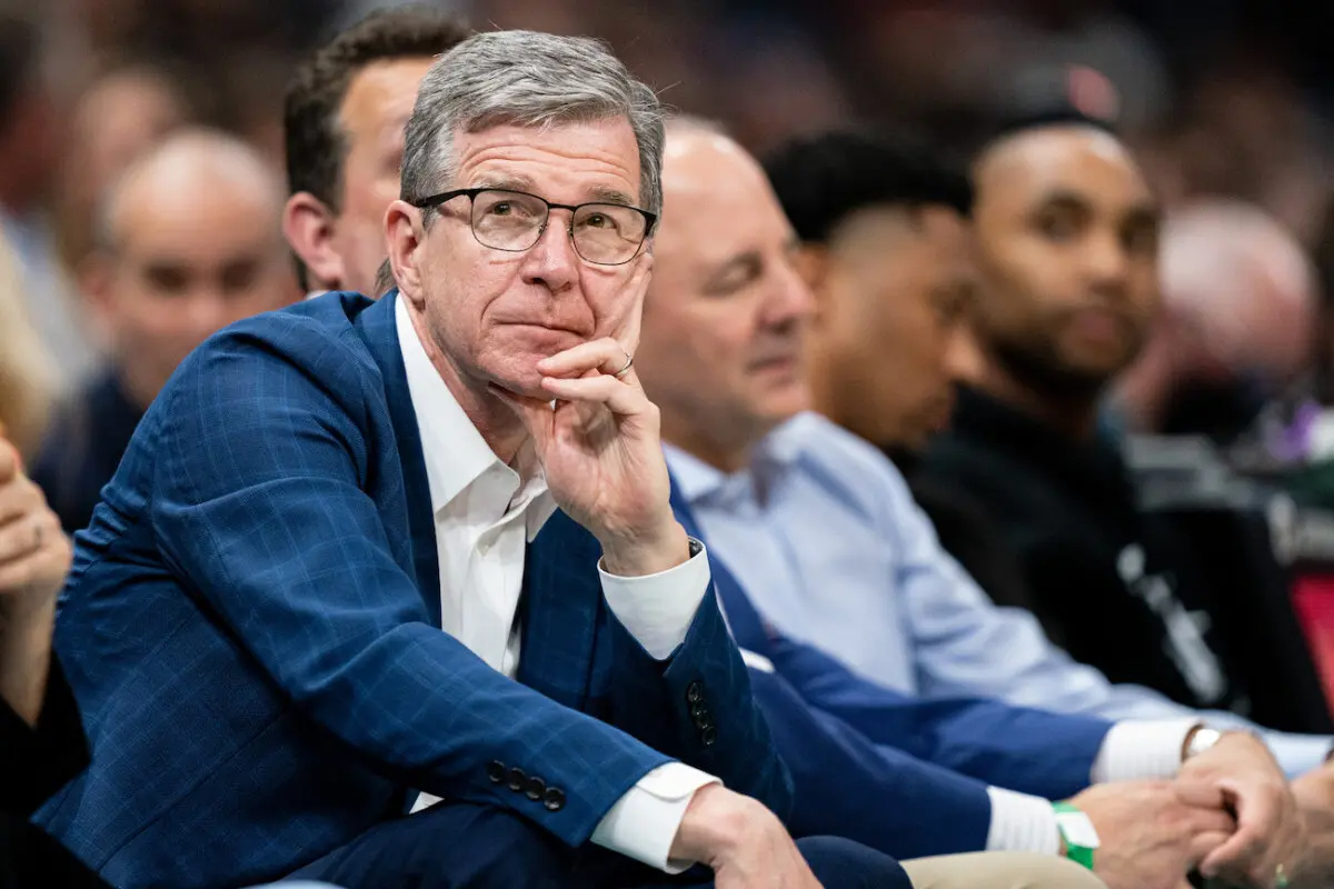 El gobernador de Carolina del Norte, Roy Cooper, observa durante un partido de la NBA en el Spectrum Center de Charlotte, Carolina del Norte, el 7 de abril de 2022. (Jacob Kupferman/Getty Images)