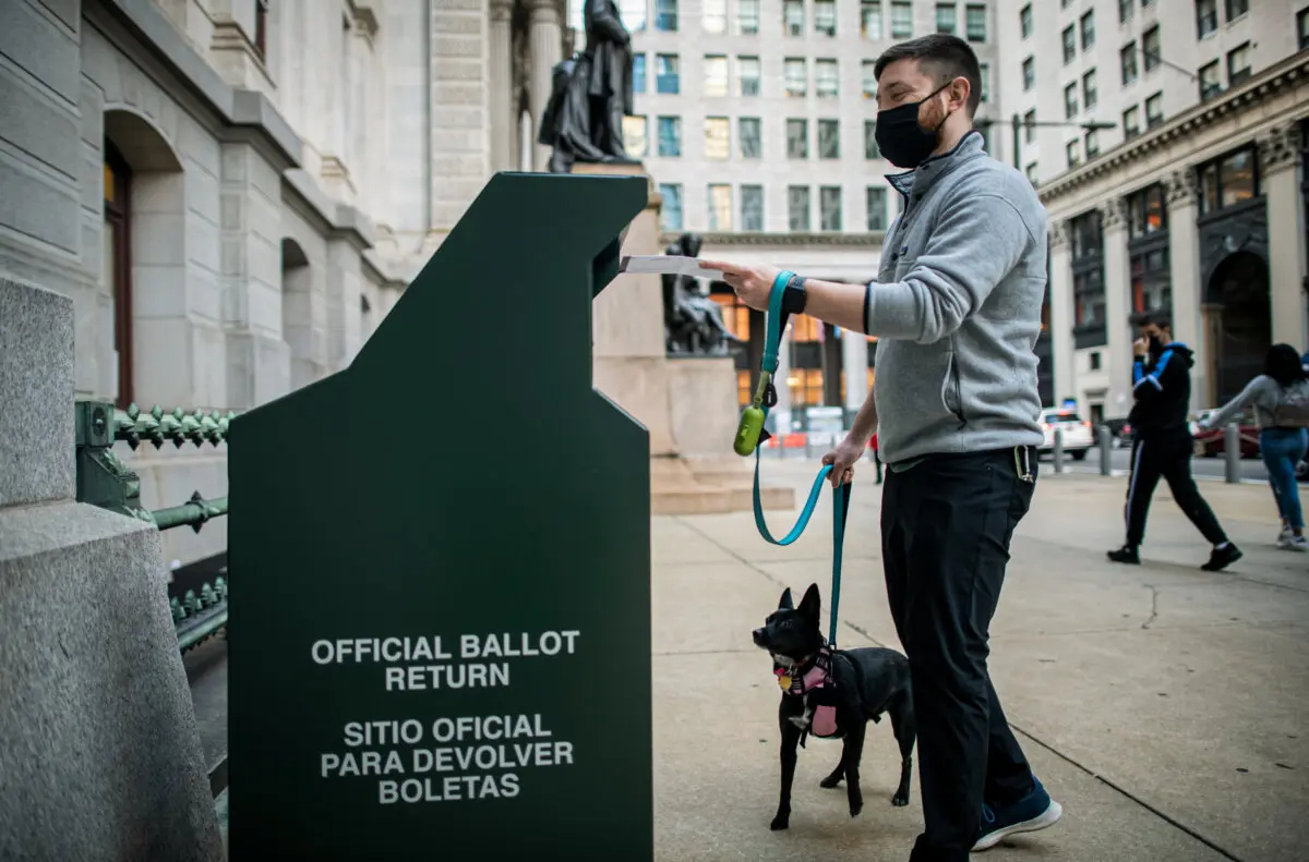 Un votante deposita su voto anticipado en un buzón fuera del Ayuntamiento el 17 de octubre de 2020, en Filadelfia, Pensilvania. (Mark Makela/Getty Images)