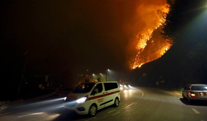 Los vehículos pasan junto a un incendio que arde junto a la carretera cerca de Sever do Vouga, una ciudad en el norte de Portugal que ha estado rodeada por incendios forestales el 16 de septiembre de 2024. (Bruno Fonseca/AP Photo)
