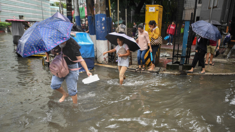 Peatones vadean una calle inundada en Manila (Filipinas) el 5 de septiembre de 2024, a causa de las fuertes lluvias debidas al monzón del suroeste influenciado por la tormenta tropical Yagi que azotó la isla principal de Luzón el 2 de septiembre. (Ted Aljibe/AFP vía Getty Images)