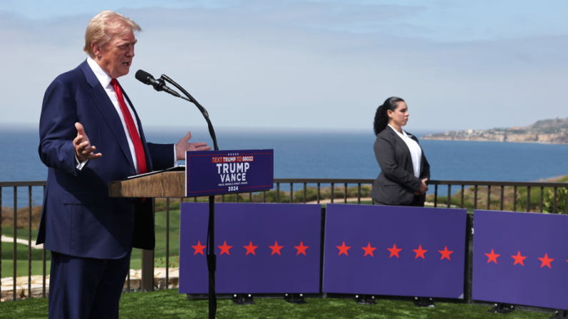 El expresidente Donald Trump habla cerca de un agente del Servicio Secreto durante una rueda de prensa en el Trump National Golf Club de Los Ángeles, en Rancho Palos Verdes, California, el 13 de septiembre de 2024. (Mario Tama/Getty Images)