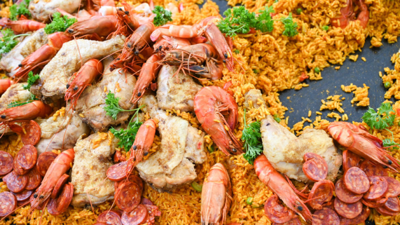 Una paella con arroz, pollo, gambas, mejillones y chorizo se cocina en una enorme sartén, en una imagen de archivo. (Matthieu Delaty/Hans Lucas/AFP vía Getty Images)