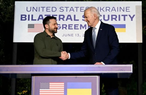 El presidente estadounidense, Joe Biden, y el presidente ucraniano, Volodymir Zelenski (izq.), se dan la mano tras firmar un acuerdo bilateral de seguridad al margen de la Cumbre del G7 organizada por Italia en la región de Apulia el 13 de junio de 2024. (Mandel Ngan/AFP vía Getty Images)