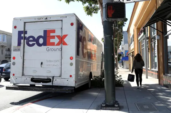 Un peatón camina junto a un camión de reparto de FedEx aparcado en San Francisco, California, el 21 de marzo de 2024. (Justin Sullivan/Getty Images)