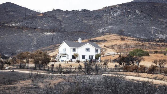 Una casa salvada por los bomberos está rodeada de daños por el incendio del aeropuerto en El Cariso Village, California, el 16 de septiembre de 2024. (John Fredricks/The Epoch Times)