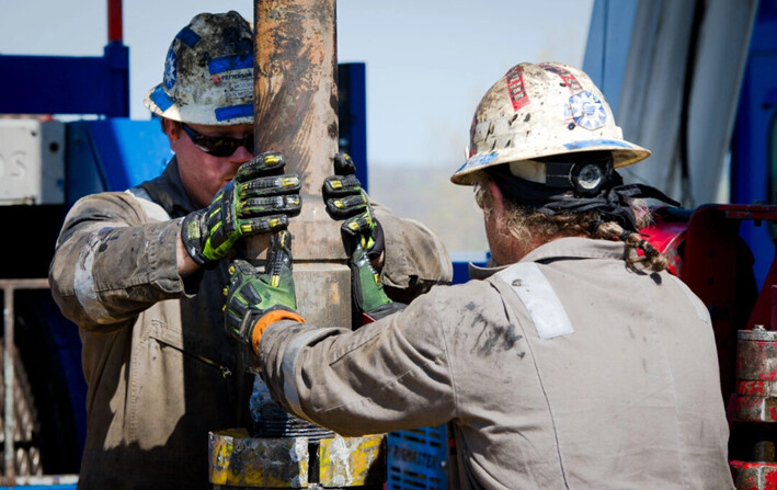 Los trabajadores cambian las tuberías en la plataforma de perforación horizontal de gas de Consol Energy que explora el yacimiento de esquisto Marcellus en las afueras de la ciudad de Waynesburg, Pensilvania, el 13 de abril de 2012. (Mladen Antonov /AFP vía Getty Images)