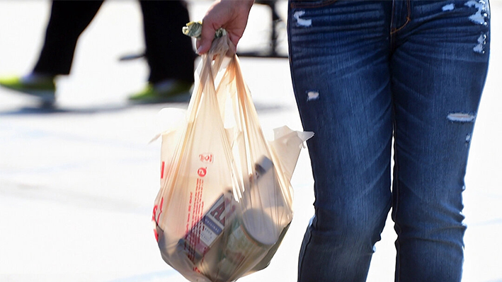 Una mujer lleva su compra en una bolsa de plástico mientras sale de un supermercado en Monterey Park, California, el 30 de septiembre de 2014. (Frederic J. Brown/AFP vía Getty Images)