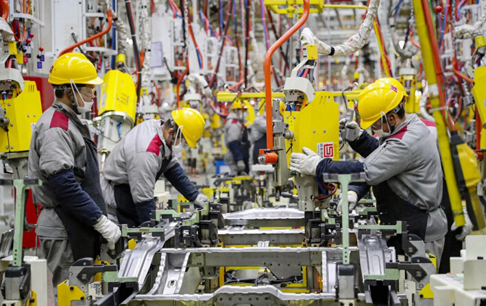 Empleados trabajando en una línea de ensamblaje de automóviles en una fábrica de Beijing Automotive en Qingdao, en la provincia oriental china de Shandong, el 14 de enero de 2023. (STR/AFP vía Getty Images)