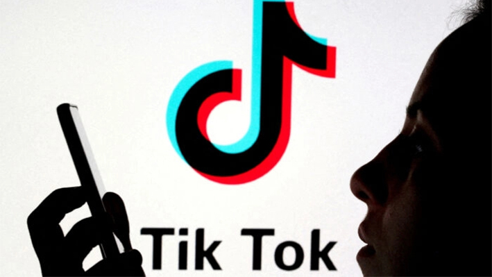 Una persona sostiene un teléfono inteligente mientras se muestra un logotipo de Tik Tok detrás en esta ilustración fotográfica tomada el 7 de noviembre de 2019. (Dado Ruvic/Reuters)