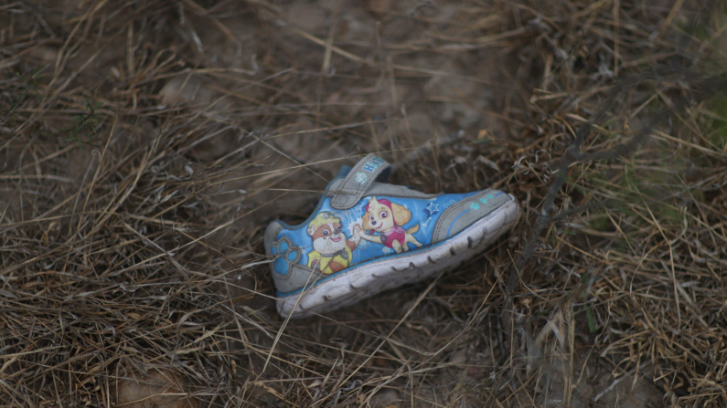 Se ve el zapato de un niño en el suelo cerca de donde la gente cruza el Río Grande en balsas guiadas por contrabandistas mexicanos el 28 de marzo de 2021 en Roma, Texas. (Joe Raedle/Getty Images)