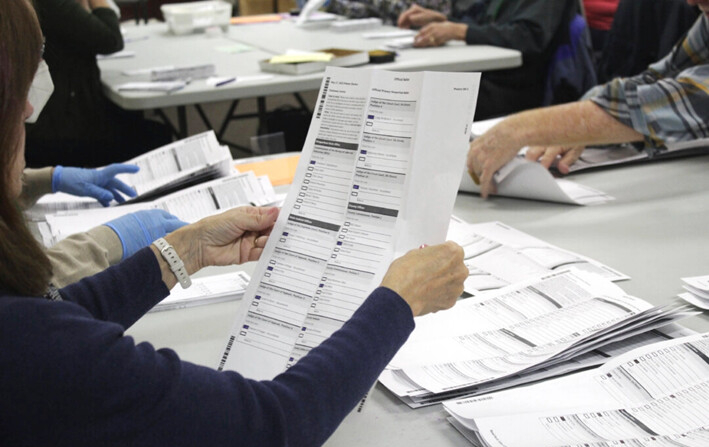 Un trabajador electoral examina una boleta en la oficina electoral del condado de Clackamas, en Oregon City, Oregón, el 19 de mayo de 2022. (Gillian Flaccus/AP Photo)