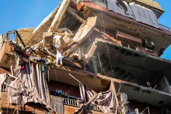 Residentes revisan un edificio parcialmente destruido en el lugar de un ataque aéreo israelí en los suburbios del sur de Beirut, el martes 24 de septiembre de 2024. (AP Photo/Hassan Ammar)