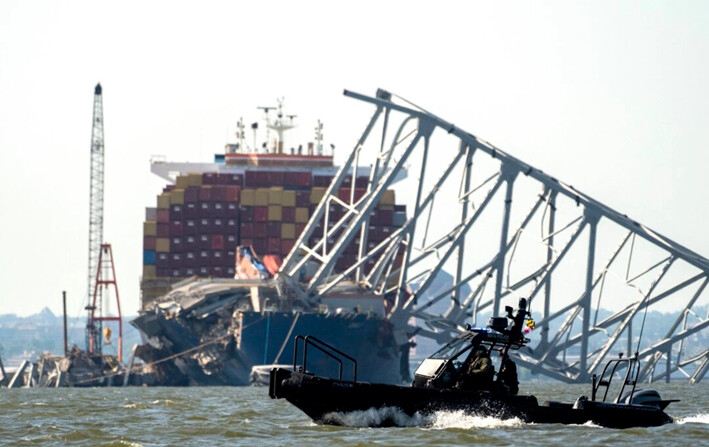 Un barco patrullero de la Autoridad de Transporte de Maryland pasa cerca de donde las cuadrillas se preparan para realizar una demolición controlada de una sección del puente Francis Scott Key, que descansa sobre el buque portacontenedores Dali, en Baltimore, el 13 de mayo de 2024. (Roberto Schmidt/AFP vía Getty Images)