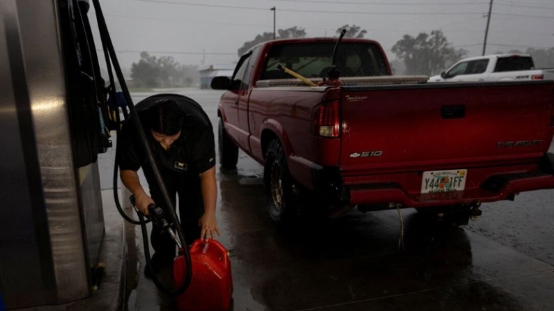 Una mujer llena un contenedor con gasolina mientras el huracán Helene se intensifica antes de su esperada llegada a tierra en el Big Bend de Florida, en Cross City, Florida, el 25 de septiembre de 2024. (Marco Bello/Reuters)