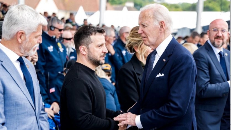 El presidente de Estados Unidos, Joe Biden (d), estrecha la mano del presidente de Ucrania, Volodymir Zelenski, durante la ceremonia conmemorativa internacional en Omaha Beach que marca el 80 aniversario del desembarco aliado del «Día D» de la Segunda Guerra Mundial en Normandía, en Saint-Laurent-sur-Mer, en el noroeste de Francia, el 6 de junio de 2024. (Ludovic Marin/AFP vía Getty Images)