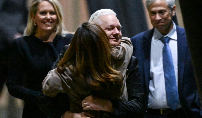 El fundador de WikiLeaks, Julian Assange (C) abraza a su esposa Stella Assange (centro L) después de llegar al aeropuerto de Canberra en Canberra, Australia, el 26 de junio de 2024. (William West/AFP vía Getty Images)