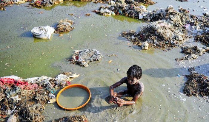 Un niño indio busca monedas y oro en las aguas contaminadas del río Ganges en Sangam después del festival Kumbh Mela, en Allahabad, el 2 de abril de 2013. (Sanjay Kanojia/AFP vía Getty Images)