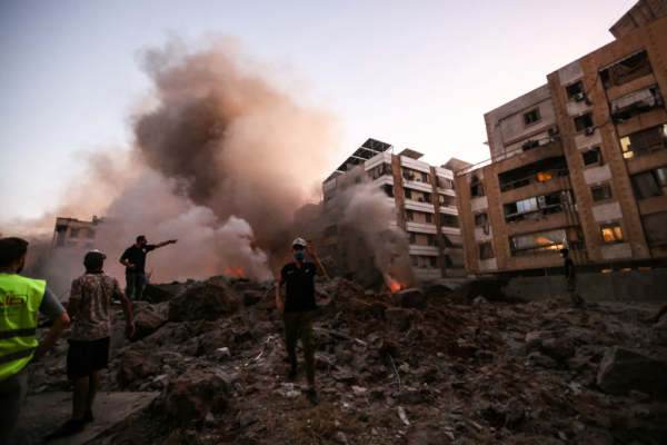 Personas y equipos de rescate entre los escombros de un edificio destruido por un ataque aéreo israelí en el barrio de Haret Hreik, en los suburbios del sur de Beirut, el 27 de septiembre de 2024. Una fuente cercana a Hezbolá dijo que los ataques masivos israelíes en los suburbios del sur de Beirut arrasaron seis edificios. (Foto de Ibrahim Amro / AFP)vía Getty Images)