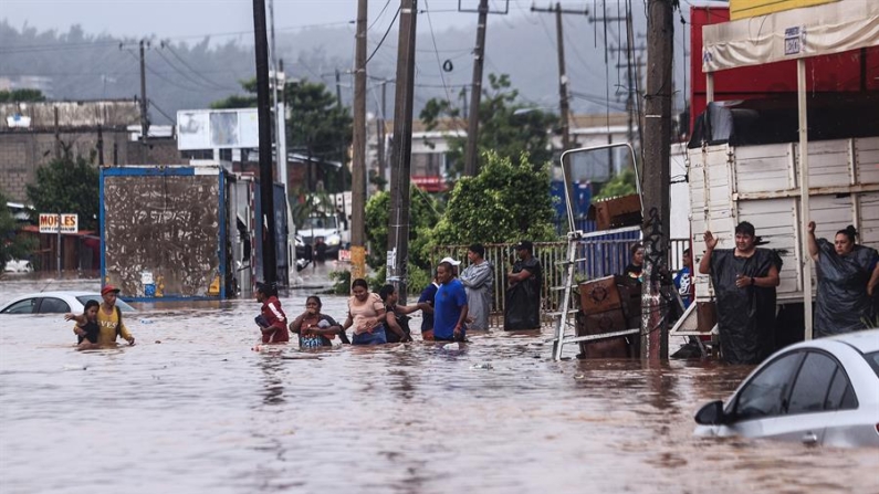 Personas caminan por una calle inundada por el paso del huracán John, el 26 de septiembre de 2024 en Acapulco (México). EFE/ David Guzmán