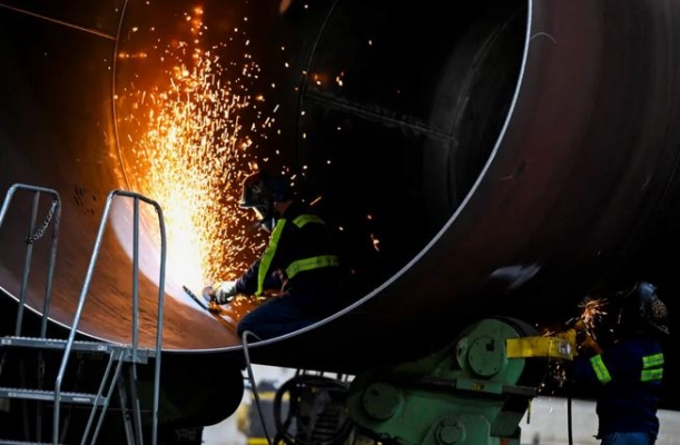 Unos hombres trabajan en un aerogenerador mientras el presidente de EE.UU., Joe Biden, visita CS Wind, el mayor fabricante de torres eólicas del mundo, en Pueblo, Colorado, el 29 de noviembre de 2023. (Andrew Caballero-Reynolds/AFP vía Getty Images)