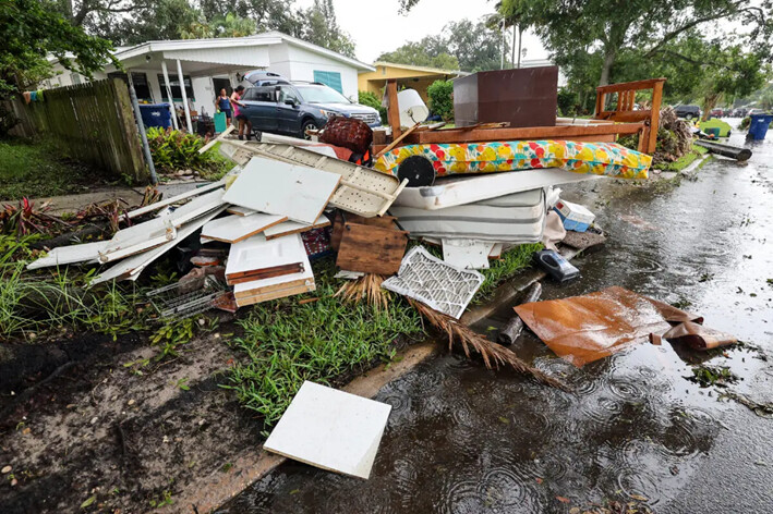 Los residentes limpian sus casas después de las inundaciones del huracán Helene en Davis Island, en Tampa, Florida, el 28 de septiembre de 2024. (Mike Carlson/AP Photo)