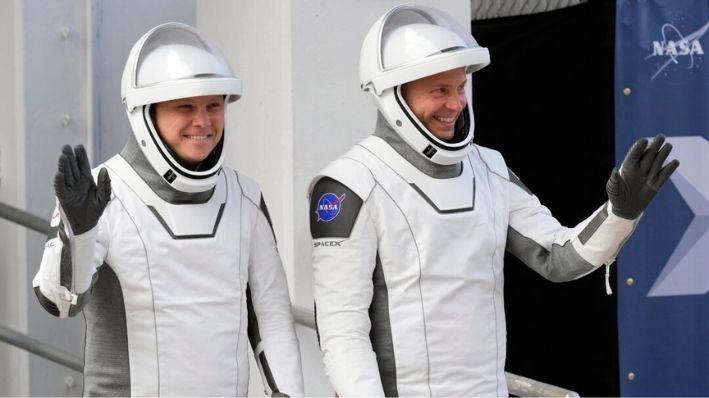 El cosmonauta de Roscosmos, Aleksandr Gorbunov (Izq.) y el astronauta de la NASA, Nick Hague, saludan al salir del edificio de operaciones y verificación en su camino al complejo de lanzamiento 40 para una misión a la Estación Espacial Internacional, en Cabo Cañaveral, Florida, el 28 de septiembre de 2024. (John Raoux/AP Photo)