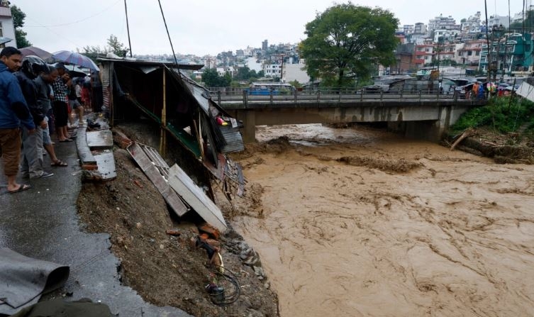 Varias personas se reúnen en la orilla del río Bagmati después de las fuertes lluvias en Katmandú, Nepal, el 28 de septiembre de 2024. (Gopen Rai/Foto AP)