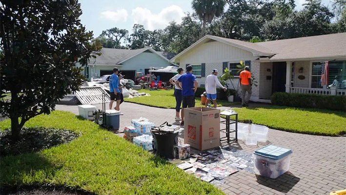 Dan Penrod (C) limpia su casa con la ayuda de vecinos y amigos en Tampa, Florida, el 29 de septiembre de 2024, después de que sufriera una inundación de más de medio metro durante el huracán Helene. (T.J. Muscaro/The Epoch Times)