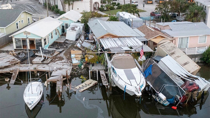 Esta vista aérea de drone muestra casas dañadas y un vehículo colapsado en el agua después de la marejada ciclónica del huracán Helene en Madeira Beach, Florida, el 28 de septiembre de 2024. (Luis Santana/Tampa Bay Times vía AP)