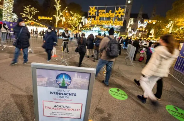 Un cartel advierte a los visitantes sobre los controles de su estado —vacunados o curados de COVID-19— la entrada del 'Christkindlmarkt' el clásico Mercado de Navidad de Viena, en la plaza frente al Ayuntamiento de Viena, Austria, el 12 de noviembre de 2021. (GEORG HOCHMUTH/APA/AFP vía Getty Images)