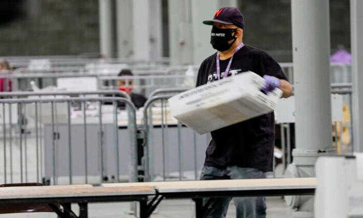 Un trabajador carga papeletas para escanearlas en el Georgia World Congress Center, en Atlanta, Georgia, el 5 de enero de 2021. (Sandy Huffaker/AFP vía Getty Images)