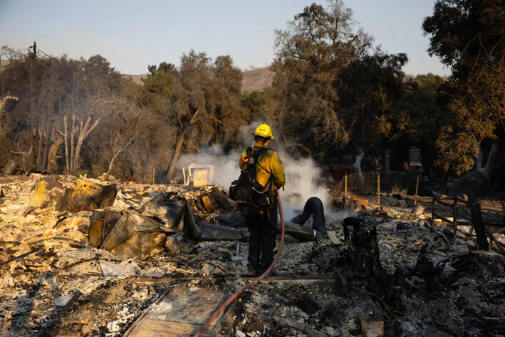 Un bombero del Departamento de Bomberos del Condado de Riverside apaga un punto caliente en una casa que se quemó en el incendio del aeropuerto, en El Cariso Village cerca de Lake Elsinore, California, el 11 de septiembre de 2024. (Zoë Meyers/AFP vía Getty Images)