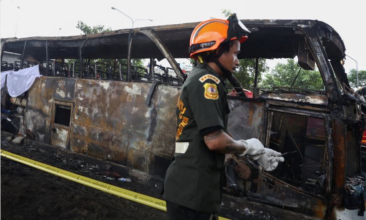 Los bomberos trabajan para extinguir un autobús en llamas que transportaba a profesores y alumnos de la escuela Wat Khao Phraya, en las afueras de Bangkok, el 1 de octubre de 2024. (Chalinee Thirasupa/Reuters)