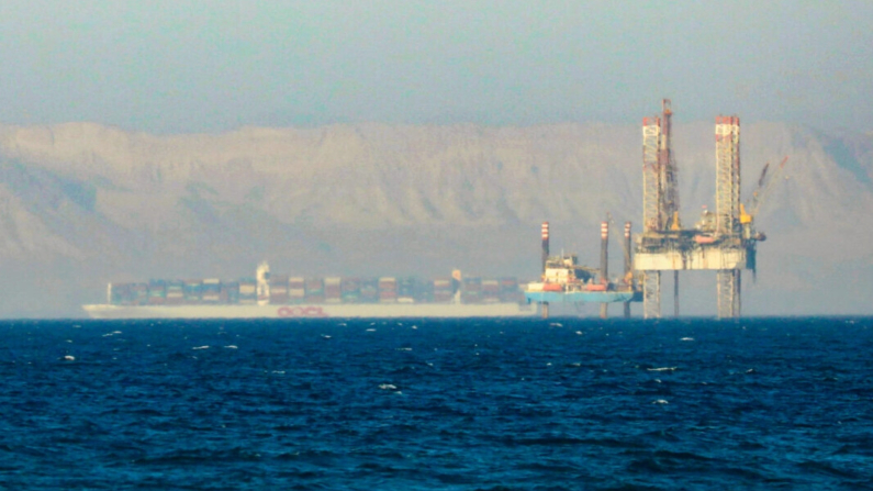 Un portacontenedores cruza una plataforma petrolífera en el Golfo de Suez en dirección al Mar Rojo antes de entrar en el Canal de Suez, a las afueras de El Cairo, Egipto, el 1 de septiembre de 2020. (Amr Abdallah Dalsh/Reuters)