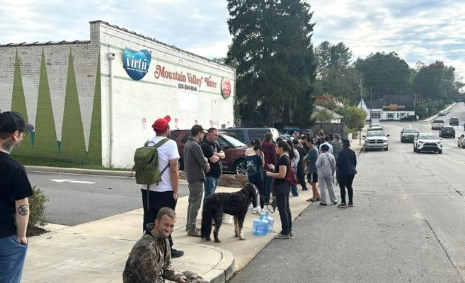 La gente espera para recoger agua en Mountain Valley Water tras el paso del huracán Helene en West Asheville, Carolina del Norte, el 30 de septiembre de 2024. ( Jeffrey Collins/Foto AP)