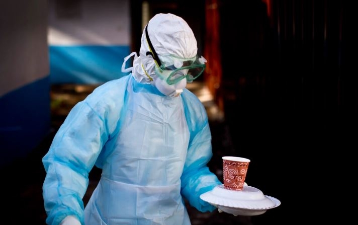 En una fotografía de archivo, un trabajador médico de la unidad de Prevención y Control de Infecciones con equipo de protección completo lleva una comida a una tienda de aislamiento en la que se encuentra un hombre en cuarentena tras entrar en contacto con un portador del virus de Marburgo, en el Hospital Nacional Kenyatta de Nairobi, Kenia. (Ben Curtis/Foto AP)