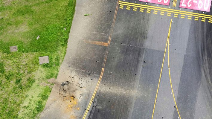 Esta fotografía tomada desde un helicóptero de Kyodo News muestra parte de una pista de rodaje dañada, en el centro, en el aeropuerto de Miyazaki, en el suroeste de Japón, el miércoles 2 de octubre de 2024, después de que se informara de una explosión. (Kyodo News vía AP)