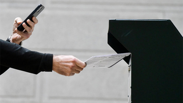 Un hombre se fotografía depositando una boleta en una urna oficial en el Ayuntamiento de Filadelfia, Pensilvania, el 27 de octubre de 2020. (Mark Makela/Getty Images)