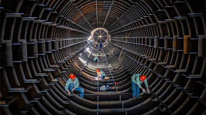 Empleados trabajan en una línea de producción de torres de tubos de acero en una fábrica de Haian, en la provincia oriental china de Jiangsu, el 1 de septiembre de 2024. (STR/AFP vía Getty Images)